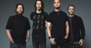 Pra Cego Ver: Foto colorida mostra os integrantes da banda Alter Bridge. Todos estão de camisetas pretas e em pé
