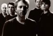 Pra Cego Ver: Foto em preto e branco tem os integrantes da banda Radiohead e todos estão em pé olhando para frente.