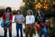 Pra Cego Ver: Foto colorida mostra os integrantes da banda Jayler em pé um do lado do outro, utilizando roupas que lembram os anos 70