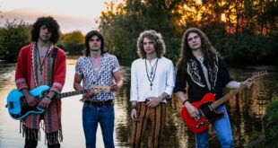 Pra Cego Ver: Foto colorida mostra os integrantes da banda Jayler em pé um do lado do outro, utilizando roupas que lembram os anos 70